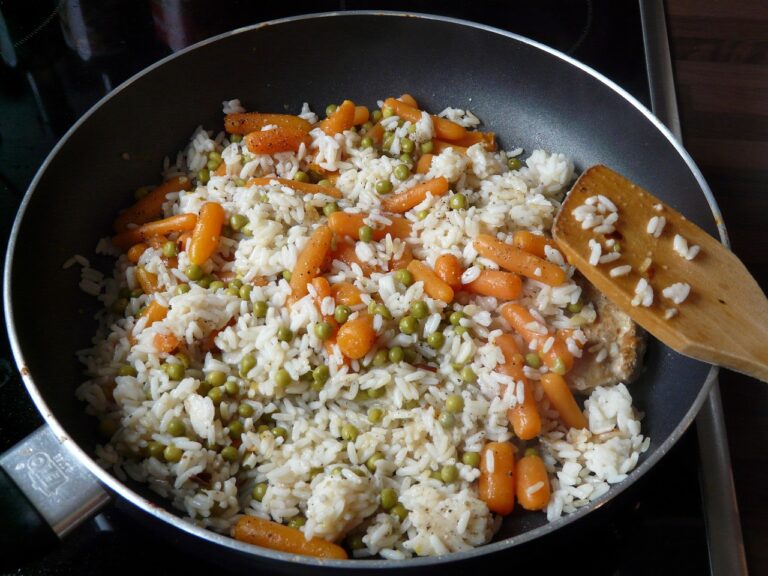 Riso pilaf in cottura, chicchi ben separati, pentola con coperchio, indicazioni per una perfetta preparazione.
