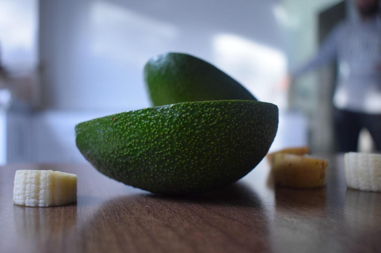 Nocciolo di avocado con stuzzicadenti immerso in un bicchiere d'acqua.